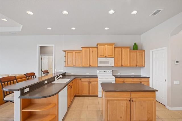 kitchen with white appliances, a center island, light tile patterned floors, and sink