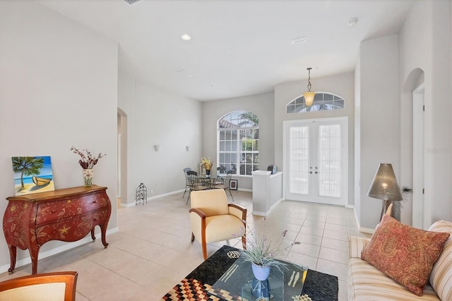 entryway featuring a high ceiling, light tile patterned flooring, and french doors