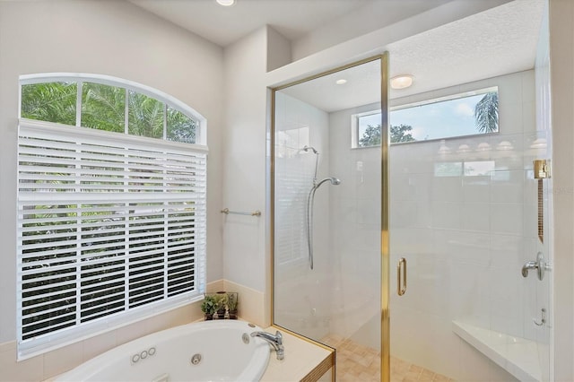 bathroom with a textured ceiling and shower with separate bathtub