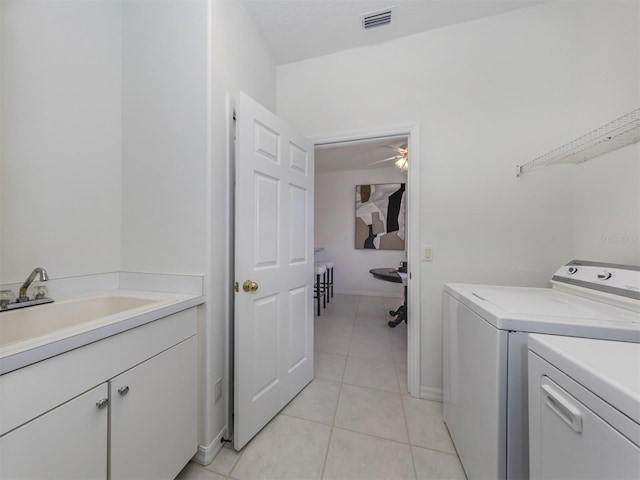 laundry room with cabinets, ceiling fan, washer and clothes dryer, sink, and light tile patterned floors