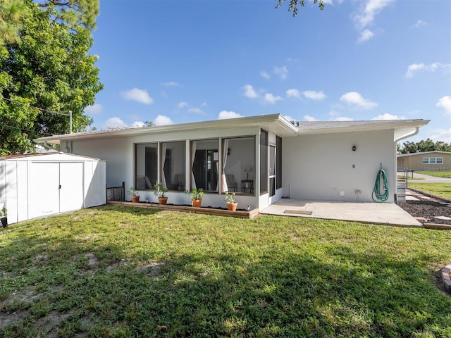 rear view of property with a shed, a patio area, a yard, and a sunroom