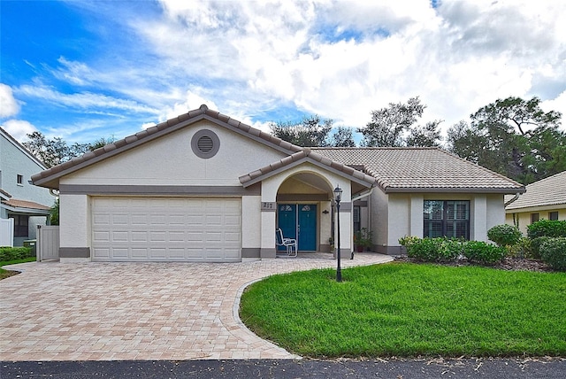 single story home with a garage and a front lawn