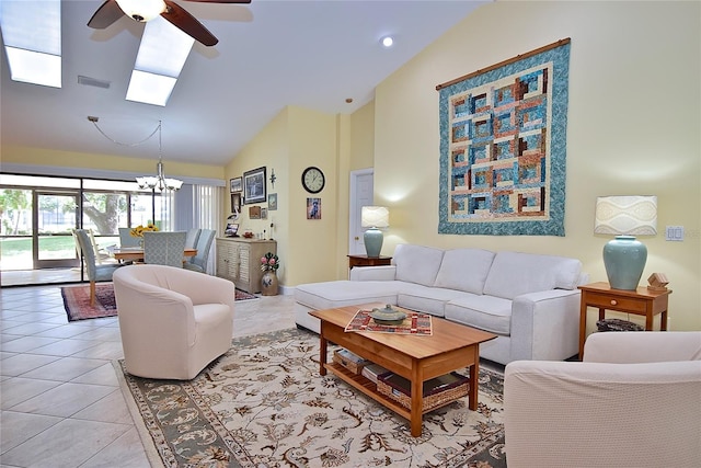 tiled living room featuring ceiling fan with notable chandelier and high vaulted ceiling