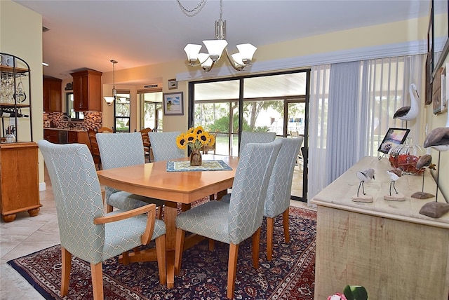 dining space featuring light tile patterned floors, sink, and a chandelier