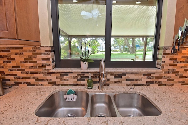 kitchen featuring light stone counters, plenty of natural light, and sink