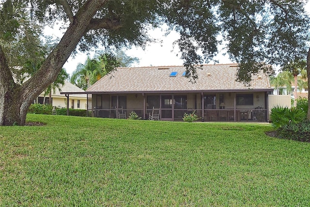 back of house with a sunroom and a yard