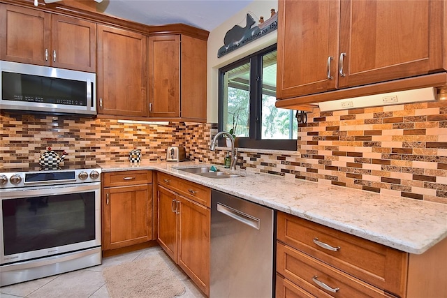 217 Carriage House Ln Unit 217, Nokomis, FL 34275 - kitchen with appliances with stainless steel finishes, a sink, brown cabinetry, and light tile patterned floors