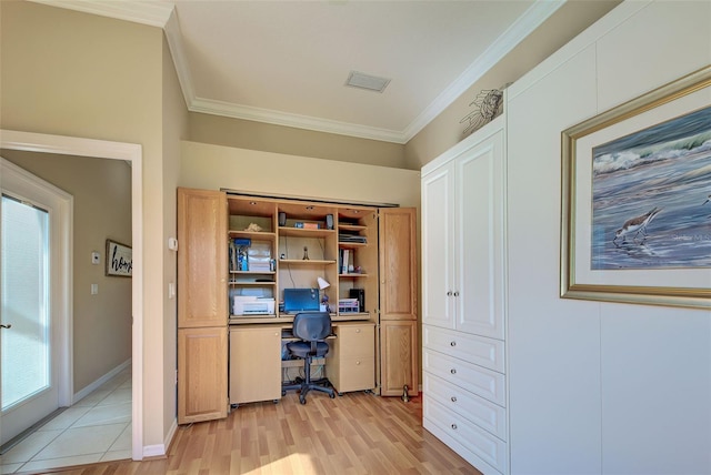 home office with crown molding, built in desk, and light hardwood / wood-style flooring