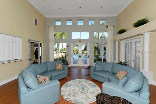 living room with ornate columns, dark hardwood / wood-style flooring, and french doors