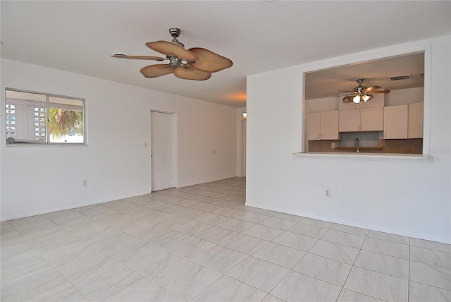 spare room with ceiling fan, light tile patterned flooring, and sink