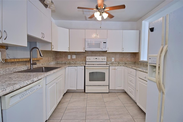 kitchen with decorative backsplash, white cabinets, white appliances, light tile patterned floors, and sink