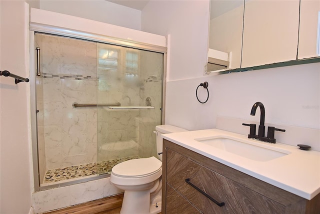 bathroom with walk in shower, vanity, toilet, and hardwood / wood-style flooring