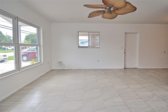 tiled spare room with ceiling fan and a wealth of natural light