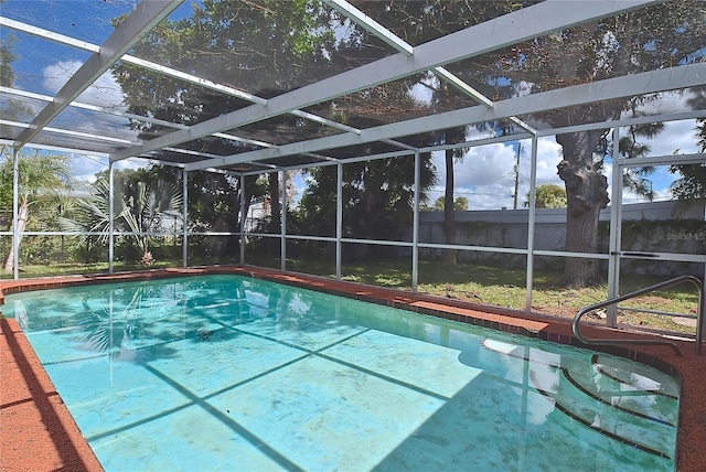 view of swimming pool featuring glass enclosure