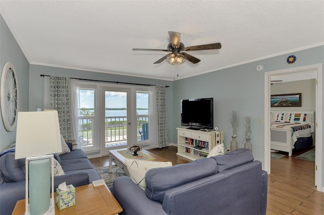 living room featuring ceiling fan, hardwood / wood-style flooring, ornamental molding, and a textured ceiling