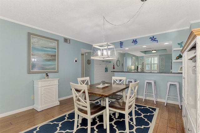 dining area featuring a textured ceiling, hardwood / wood-style floors, and crown molding