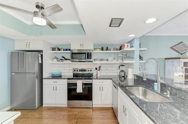 kitchen with light hardwood / wood-style floors, sink, stainless steel appliances, and white cabinets