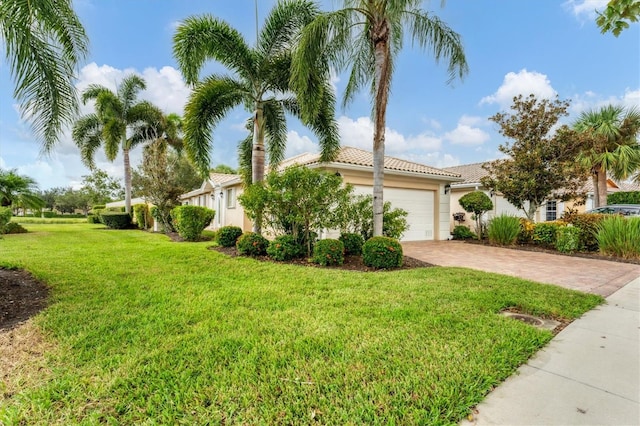 mediterranean / spanish home featuring a garage and a front lawn