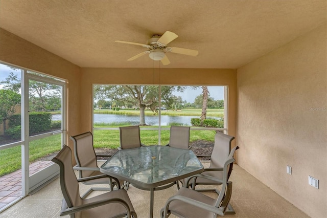 sunroom with a water view and ceiling fan