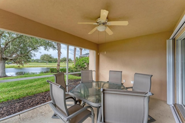 sunroom featuring a water view and ceiling fan