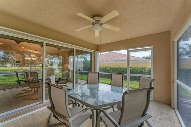 sunroom / solarium with ceiling fan with notable chandelier