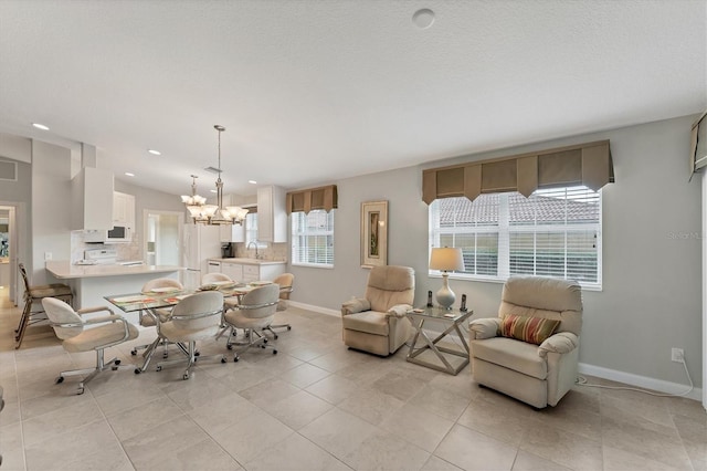 tiled living room featuring an inviting chandelier, sink, and plenty of natural light