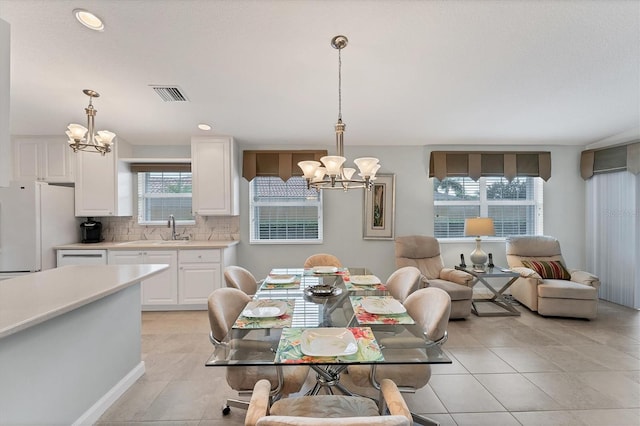 tiled dining area with sink and an inviting chandelier