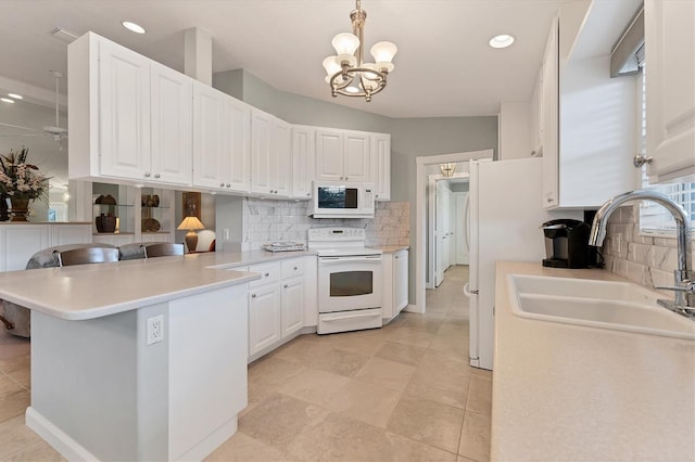 kitchen featuring electric range oven, white cabinetry, kitchen peninsula, and hanging light fixtures