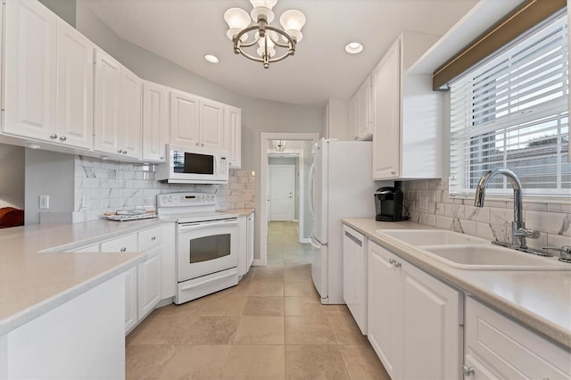 kitchen with white cabinetry, tasteful backsplash, sink, and white appliances