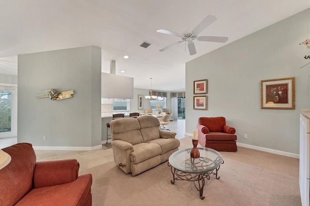 carpeted living room with ceiling fan with notable chandelier