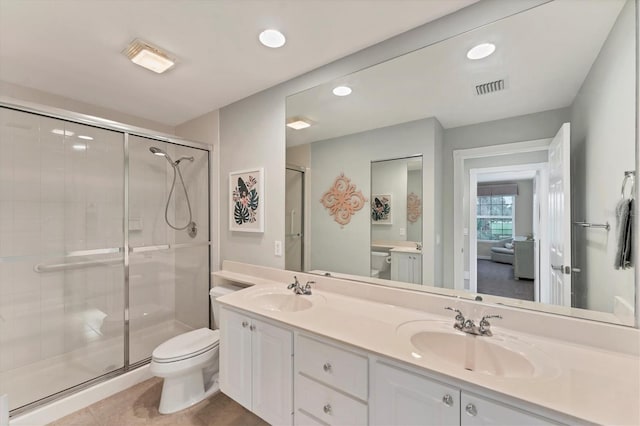 bathroom with vanity, tile patterned floors, toilet, and an enclosed shower