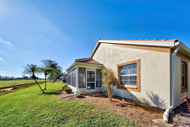 view of property exterior featuring a yard and a sunroom