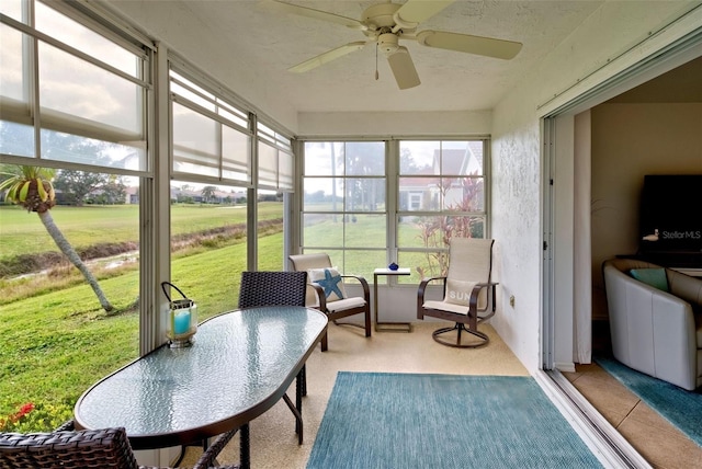 sunroom / solarium featuring ceiling fan and plenty of natural light