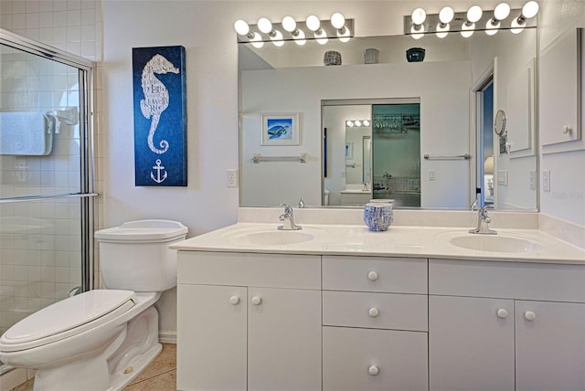 bathroom with toilet, a shower with door, vanity, and tile patterned floors