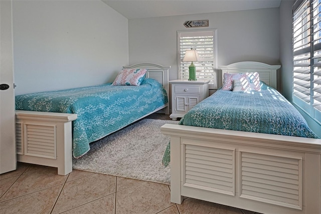 bedroom with multiple windows and tile patterned floors