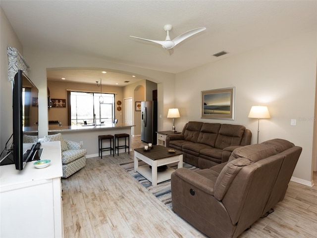 living room featuring light hardwood / wood-style floors and ceiling fan