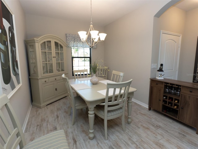 dining space featuring an inviting chandelier and light wood-type flooring