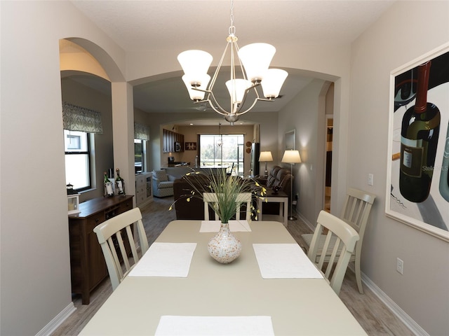 dining space featuring wood-type flooring and a chandelier