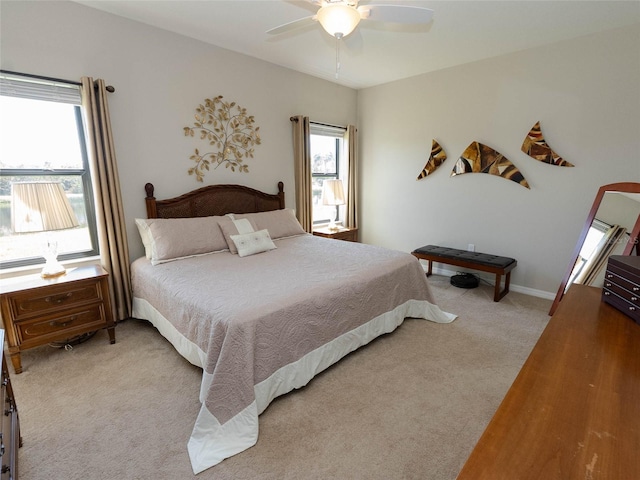 bedroom featuring light carpet, multiple windows, and ceiling fan