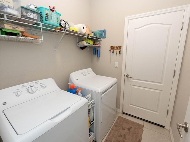 laundry room with washer and clothes dryer and light tile patterned floors