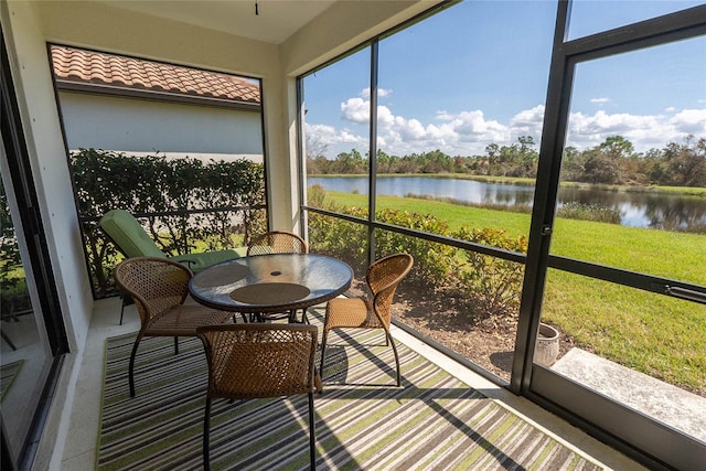 sunroom featuring plenty of natural light and a water view