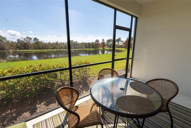 sunroom featuring a wealth of natural light and a water view