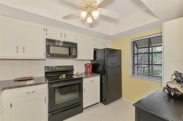 kitchen with ceiling fan, tasteful backsplash, a tray ceiling, white cabinets, and black appliances