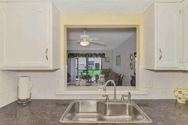 kitchen featuring ceiling fan, sink, backsplash, a textured ceiling, and white cabinets