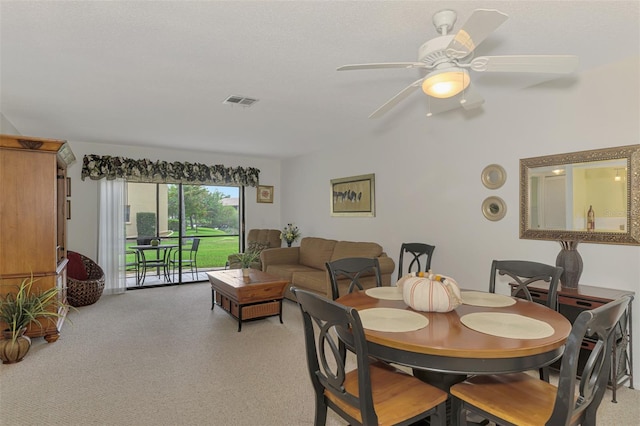 carpeted dining space featuring ceiling fan