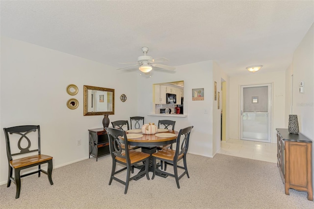 carpeted dining room with ceiling fan and a textured ceiling