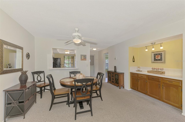 carpeted dining room with ceiling fan