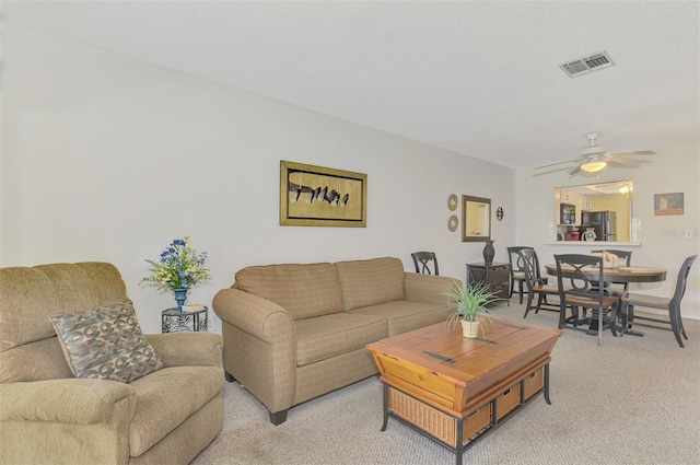 carpeted living room featuring ceiling fan