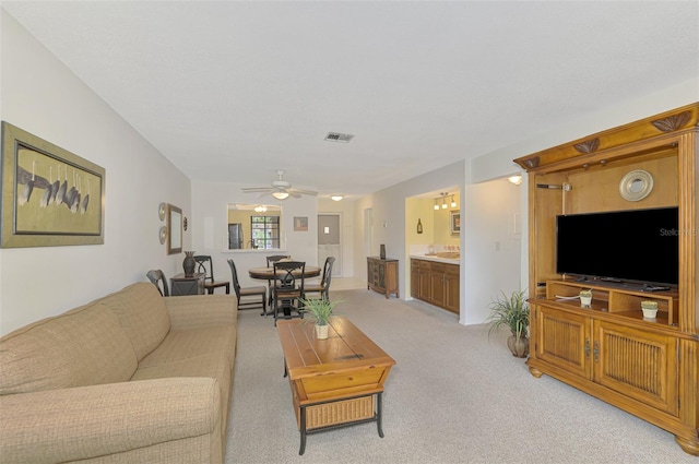 carpeted living room with ceiling fan