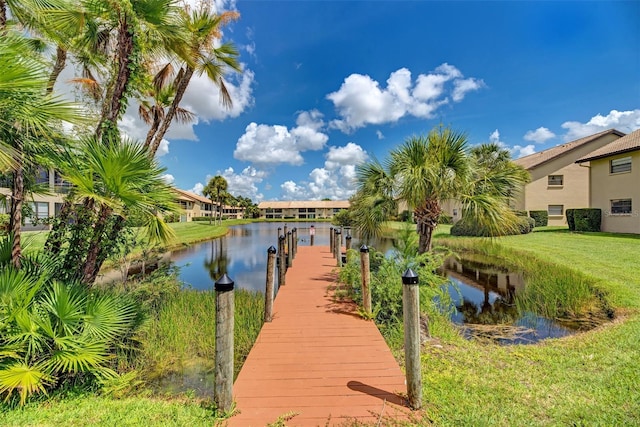 view of dock featuring a lawn and a water view